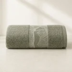 Serenity Textured Towel in sage green, rolled, with a woven leaf-pattern band
